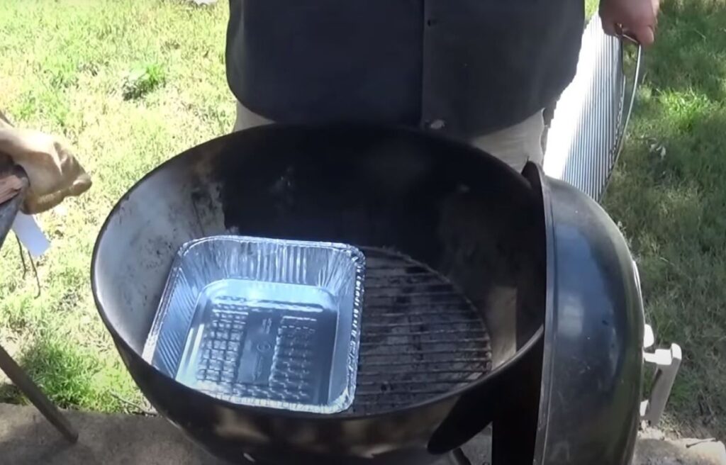 Foil pan method for using wood chips on a charcoal grill