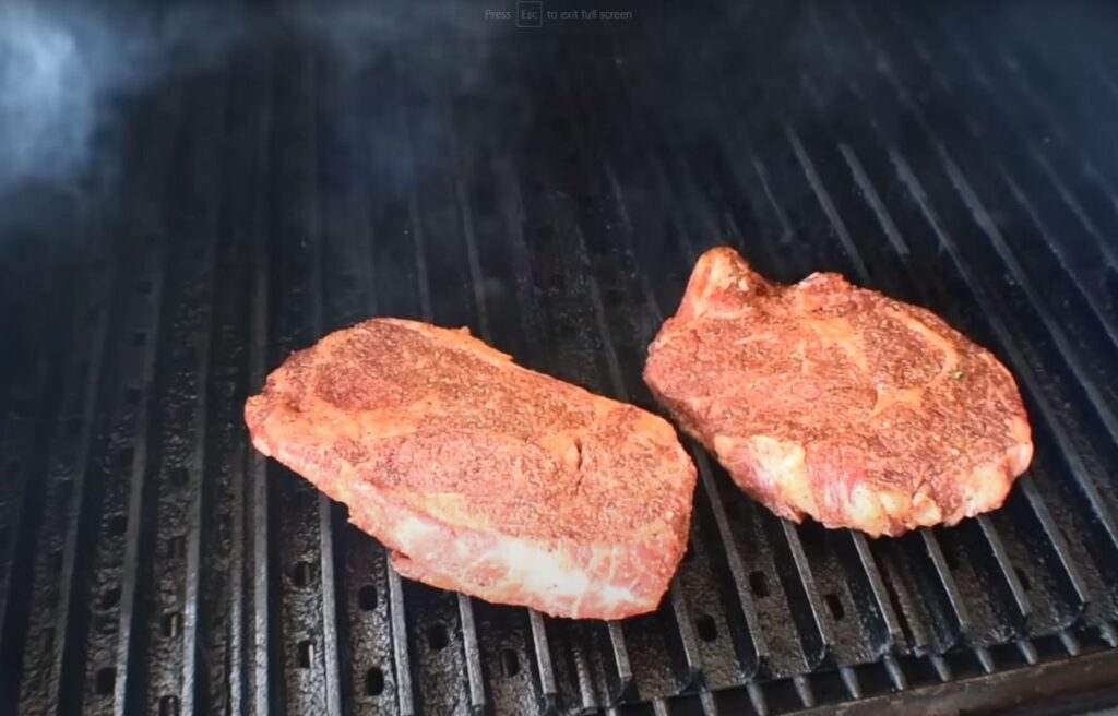 Grilling a couple of steaks on the lower rack of a pellet grill
