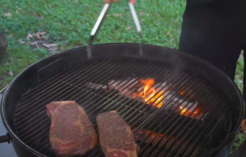 Moving the ribeye steaks to the less hot part of the grill