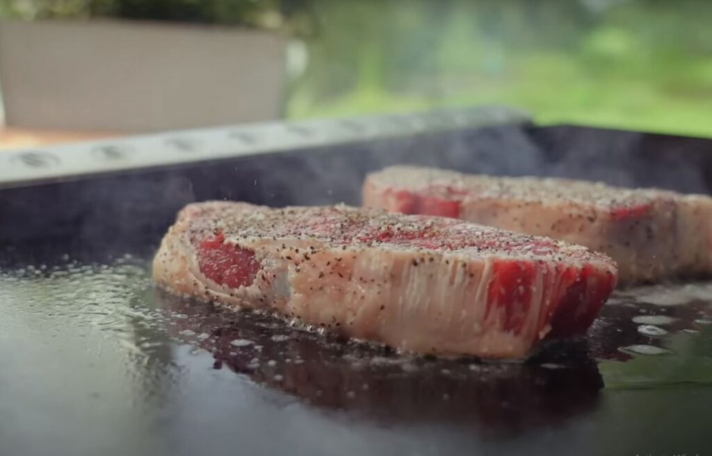 Cooking steaks on a flat top grill